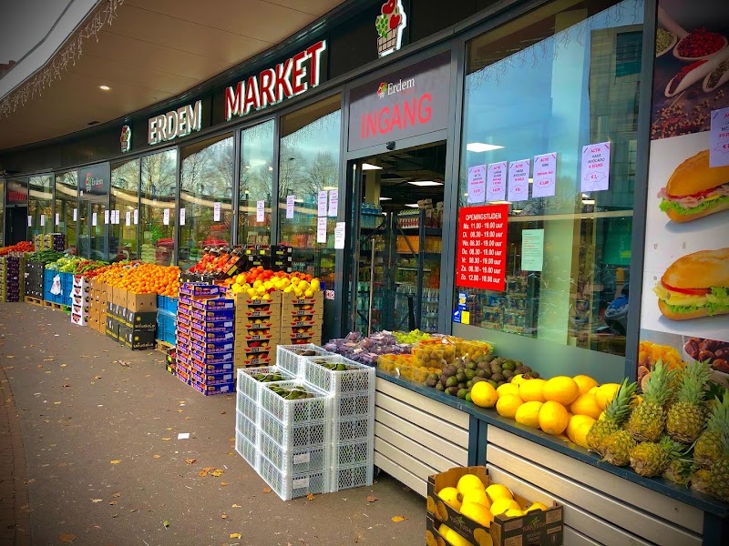De winkelpui van Erdem Market aan het Bachplein, met kratten groente en fruit voor de deur.
